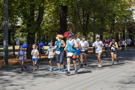 Erwachsene und Kinder joggen bei Sonneschein auf der Prater Hauptallee beim ROTE NASEN LAUF